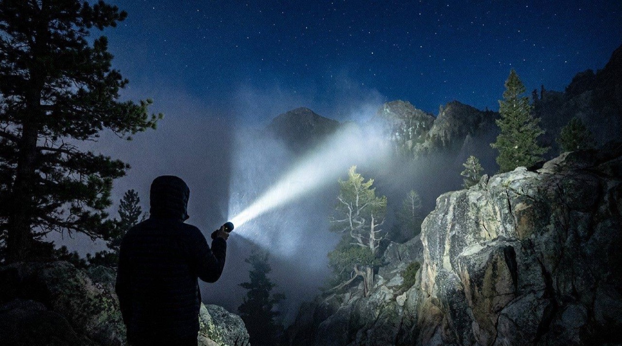 LED flashlight illuminating a mountain trail during a night hiking expedition